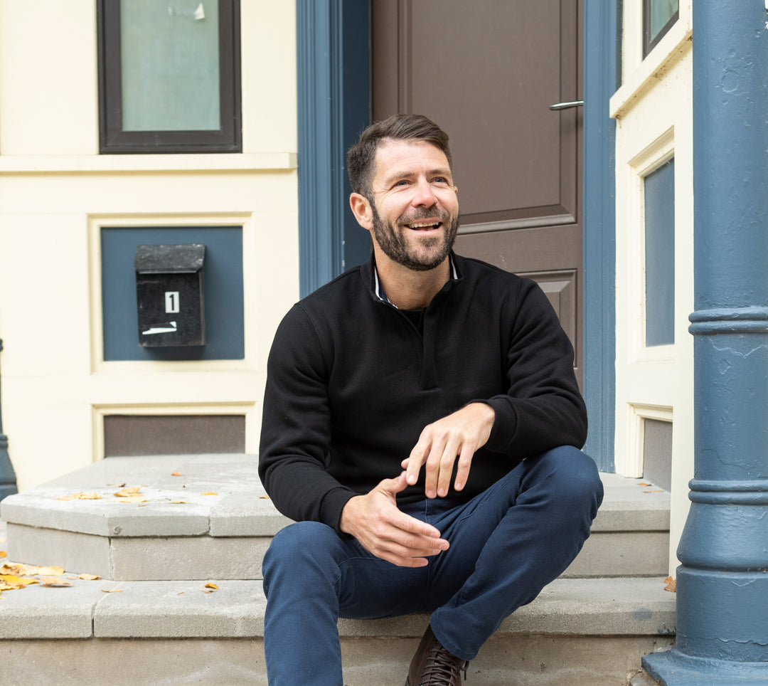 Model wearing Quarter-Zip Sweatshirt and Weekend Jeans sitting on stoop